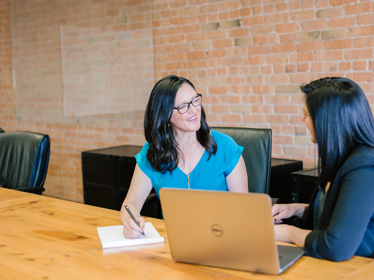 A licensed agent reviewing plan options with a client at a table