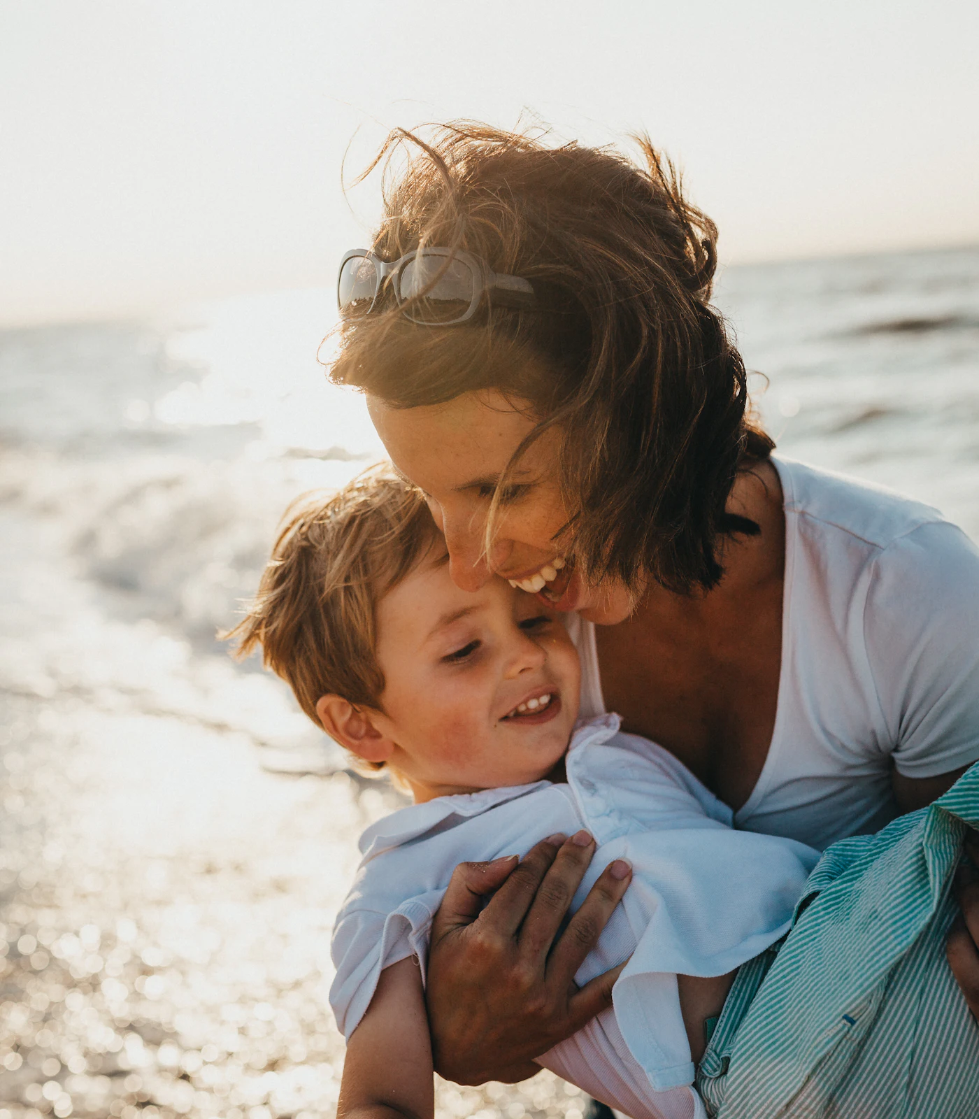 A mother holding her young son outdoors